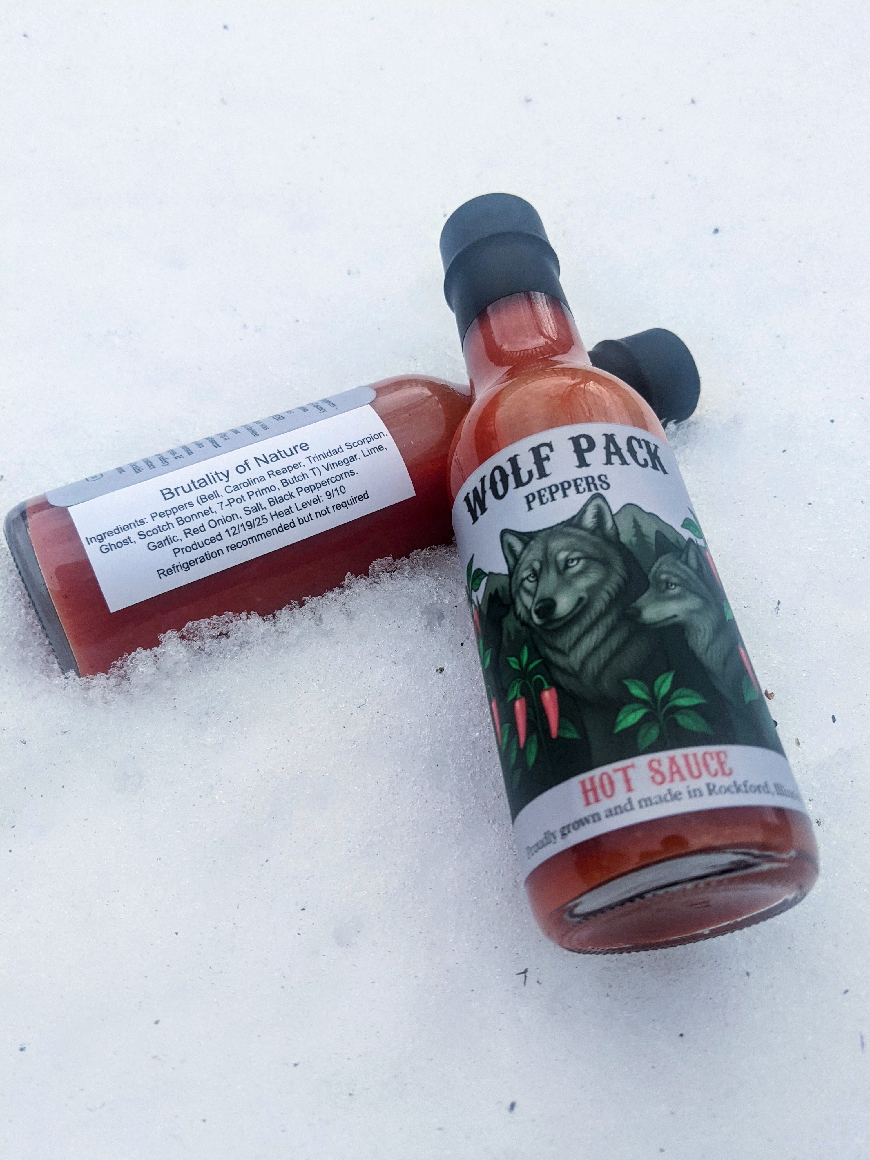 Two bottles of Wolf Pack Peppers Brutality of Nature hot sauce