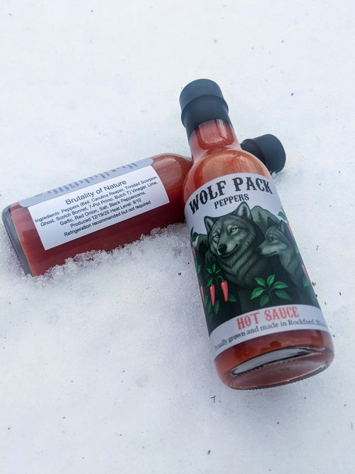 Two bottles of Wolf Pack Peppers Brutality of Nature hot sauce