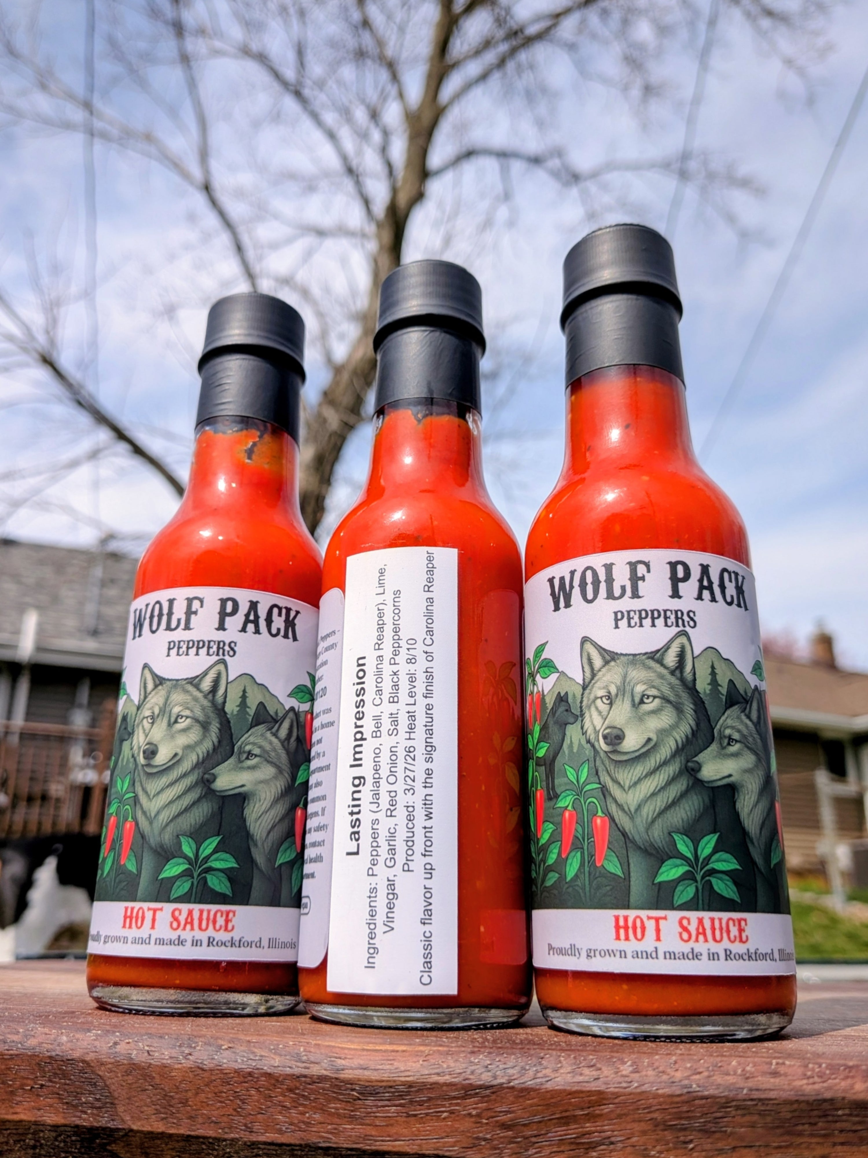 Three bottles of Wolf Pack Peppers Lasting Impression hot sauce