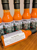 Several bottles of Wolf Pack Peppers Pack Mentality hot sauce